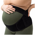 Mom-to-be wearing a black pregnancy support belt on a white background.