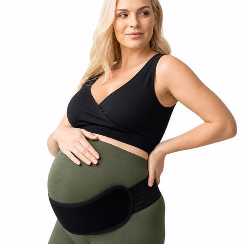 An expectant mother wearing an adjustable black abdominal support pad on a white background. 