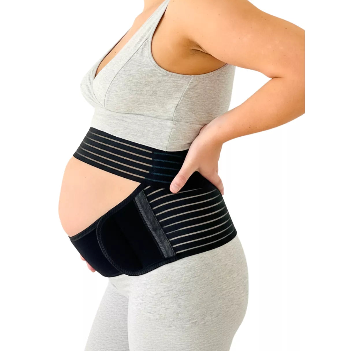 A pregnant woman wearing a black maternity support belt on a white background.