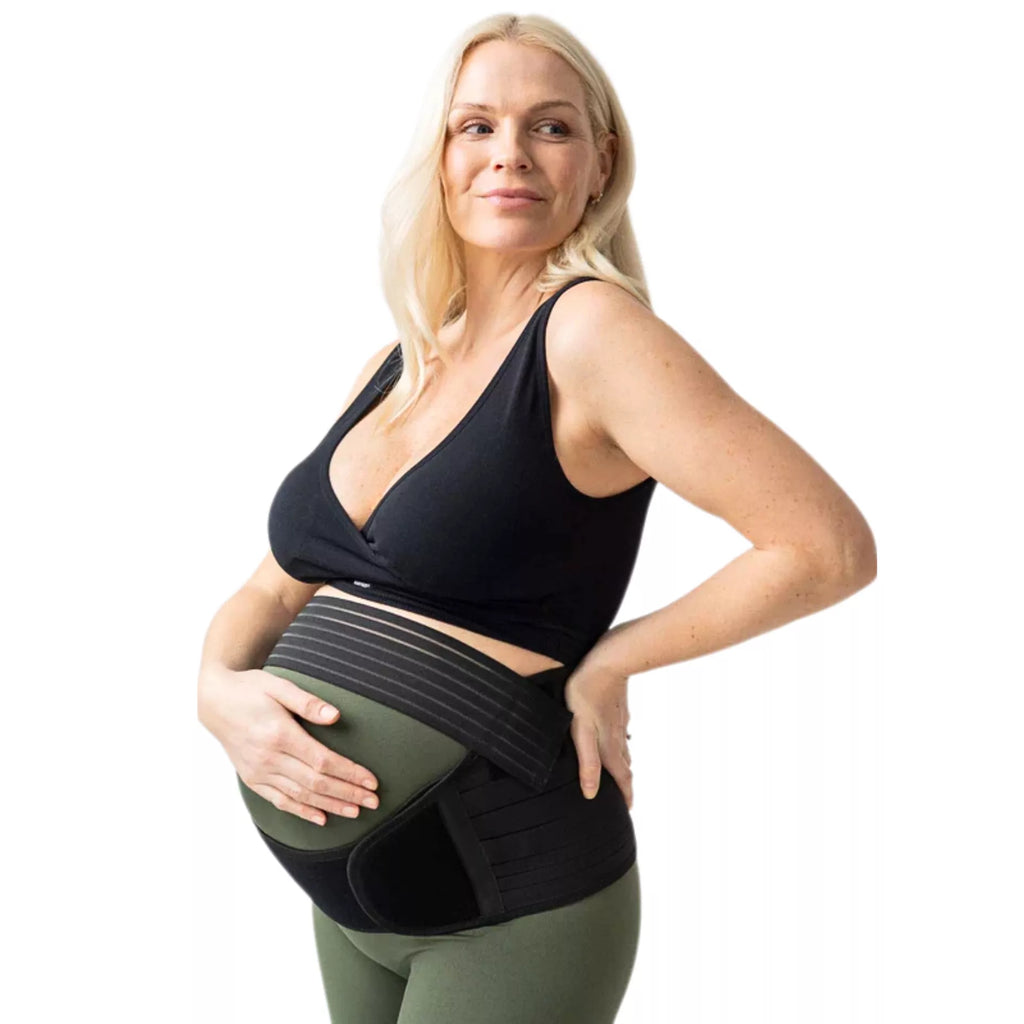 Pregnant woman wearing black maternity belly support belt in second trimester, front view on white background Qatar.